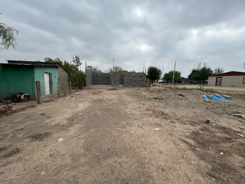 El lote de tierra con las casas vecinas al fondo